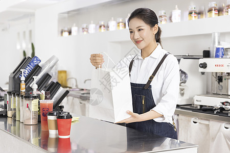 奶茶吧台饮品店女性服务员递出外卖奶茶背景