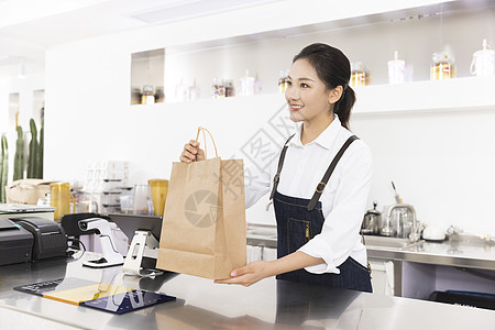 饮品店女性服务员递出外卖奶茶高清图片