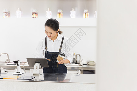 女服务员端着咖啡操作电脑图片