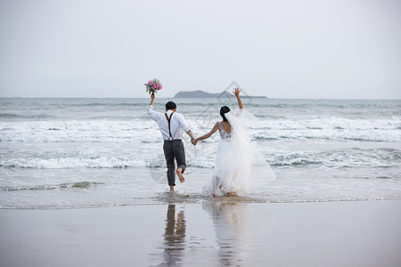 唯美海滩海边沙滩情侣夫妻奔向大海背景