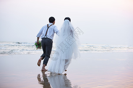 海边情侣海边沙滩情侣夫妻奔向大海背景