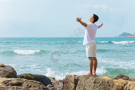 海岛旅游男孩青年男性张开手臂拥抱大海背影背景