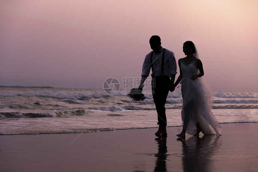 海边沙滩日落情侣散步剪影