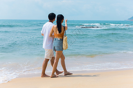 沙滩美女夏日情侣海边沙滩散步背景