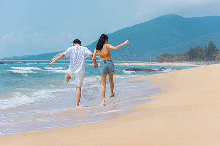 海边情侣夏日情侣海边沙滩散步背景