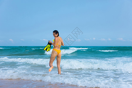 海边潜水孩子夏日比基尼美女拿着浮潜装备走向大海背景