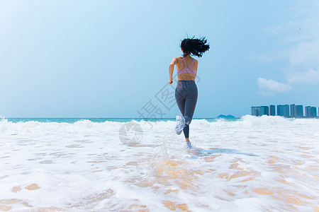 有氧运动夏日海边沙滩女性运动奔向大海跑步背影背景