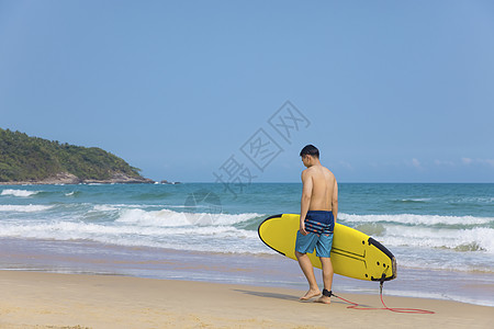 海边沙滩裤青年男性拿冲浪板图片