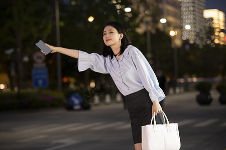 夜晚购物夜晚下班打车的女性背景