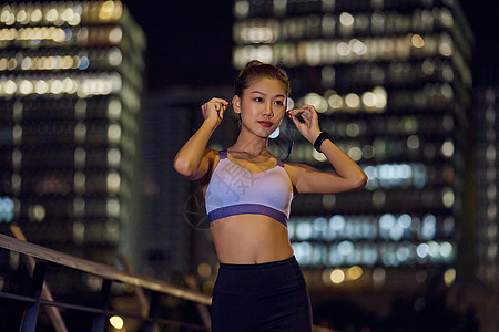 城市户外夜跑女性戴耳机图片