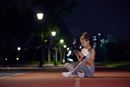 城市户外夜景健身美女看手机高清图片