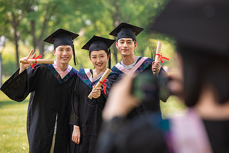 女生用手机给同学们拍毕业照图片