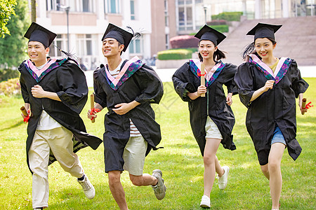 年轻大学同学穿学士服奔跑图片