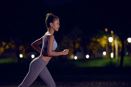 美女在户外跑步夜晚在公园健身的人背景