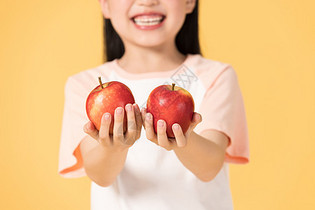 拿着苹果的小女孩的手部特写图片