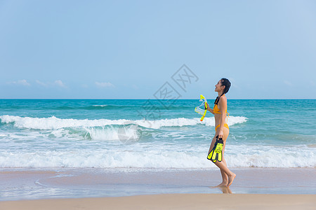 夏日比基尼美女拿着浮潜装备走向大海图片