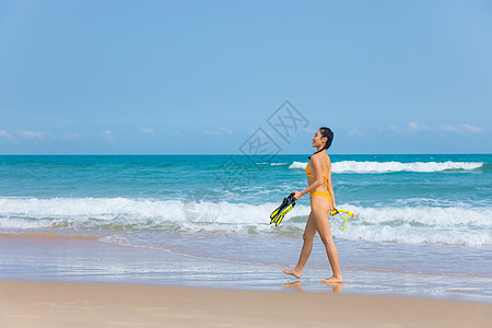 夏日比基尼美女拿着浮潜装备走向大海图片