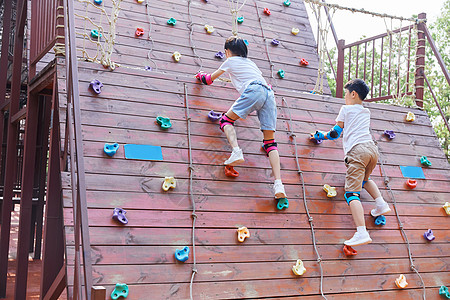 游乐园玩耍儿童户外练习攀岩墙背景