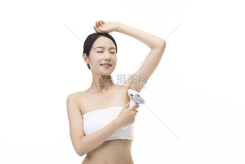 美容女性使用脱毛仪器脱腋毛图片