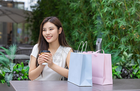 美女购物消费坐在室外咖啡厅图片