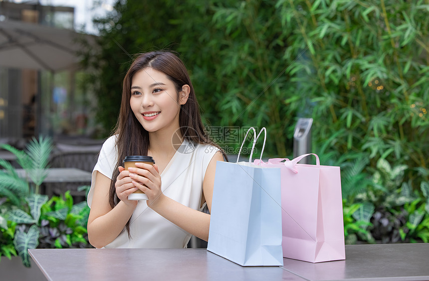 美女购物消费坐在室外咖啡厅图片