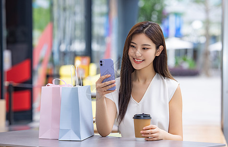 美女逛街购物喝咖啡看手机图片