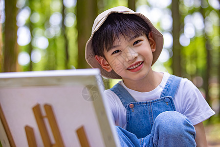 在树林里画画的小男孩图片