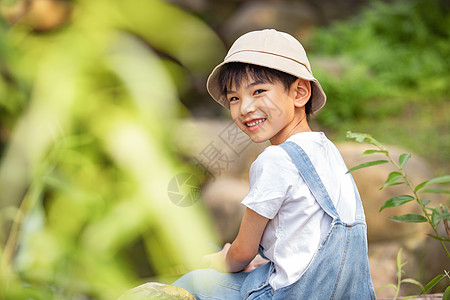 户外用望眼镜眺望远方的小男孩背景图片