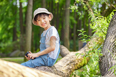 户外用望眼镜眺望远方的小男孩背景图片