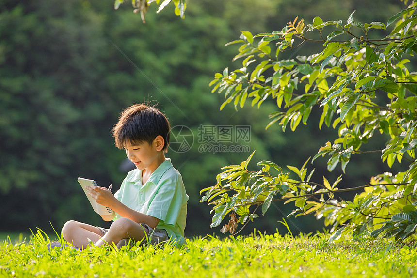 在户外写观察日记的小男孩图片