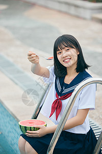 夏日制服美女泳池边吃西瓜背景