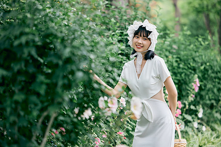 年轻女性法式美女花园里散步背景