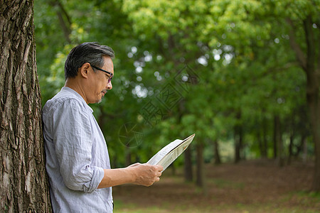 中年男性在户外看书背景图片