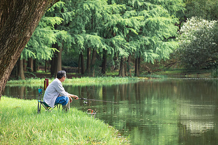 湖边钓鱼在湖边悠闲钓鱼的男性背景