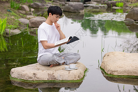 男性在户外看书思考图片