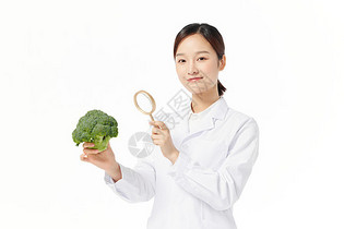 营养学家手拿放大镜观察蔬菜图片