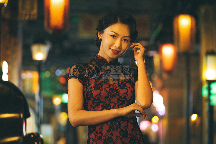 城市夜晚霓虹灯下身穿红色旗袍的美女图片