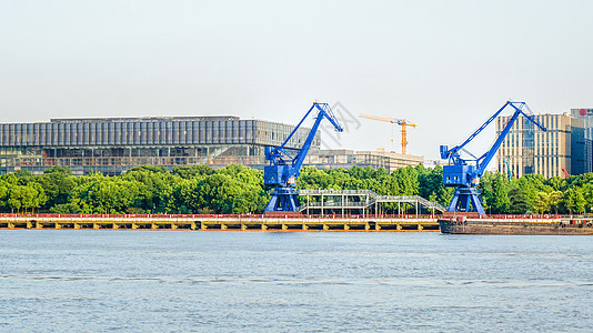 港口作业江边码头的工业建筑蓝色塔吊背景