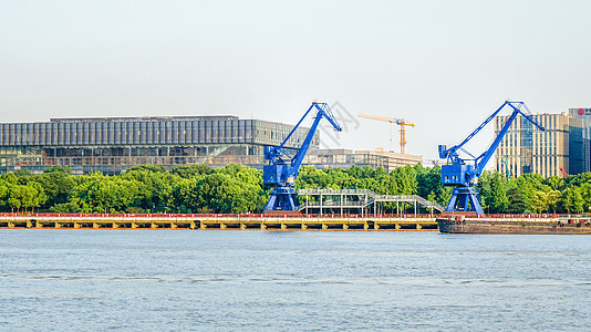江边码头的工业建筑蓝色塔吊图片