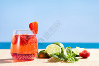 蓝色海边背景前的饮品和水果图片