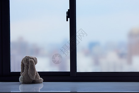 窗台上孤独的玩偶静物图片