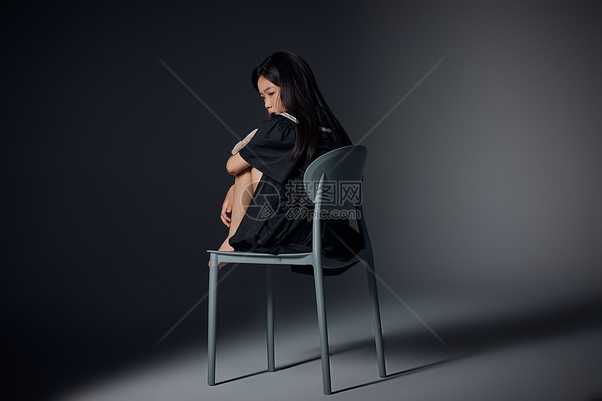 坐在椅子上的孤独小女孩