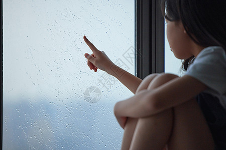 伤心孤单的小女孩摸着窗外图片