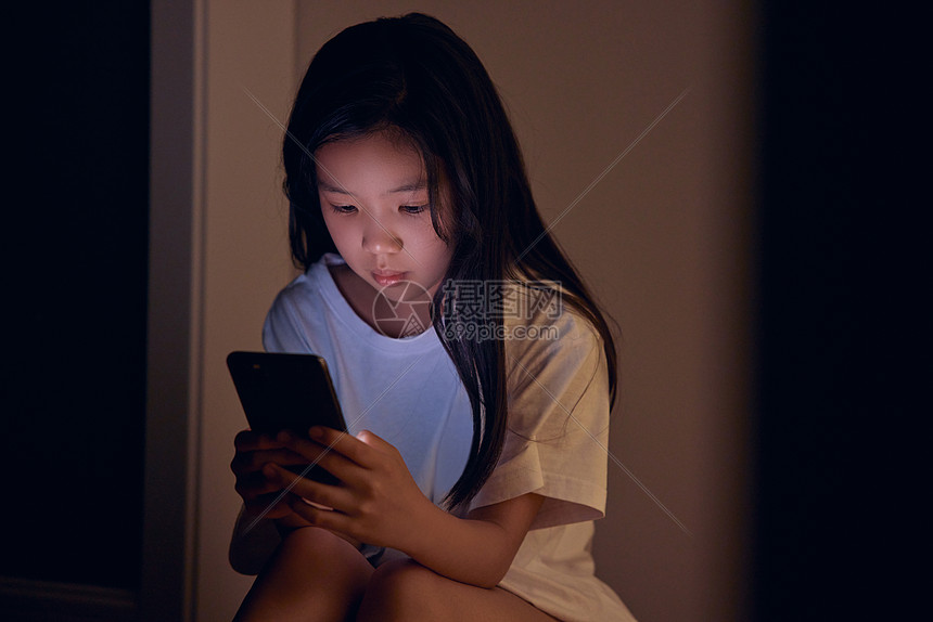 小女孩夜晚看手机