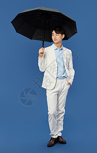 绅士男青年打着雨伞高清图片