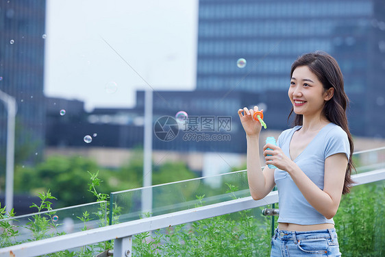 年轻美女户外吹泡泡图片