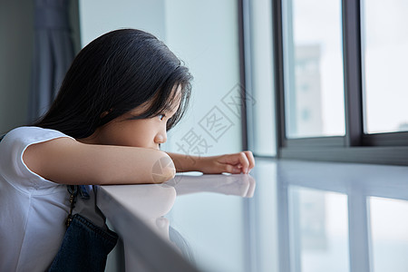 趴在窗边女孩孤单的留守儿童趴在窗边背景