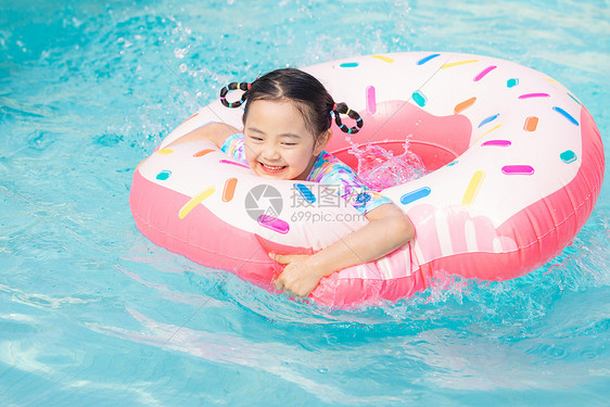 小女孩趴在游泳圈上开心戏水图片