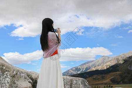 新西兰山顶正在拍照的女孩背影图片