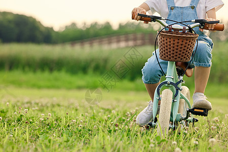 小男孩户外草坪上骑车特写图片